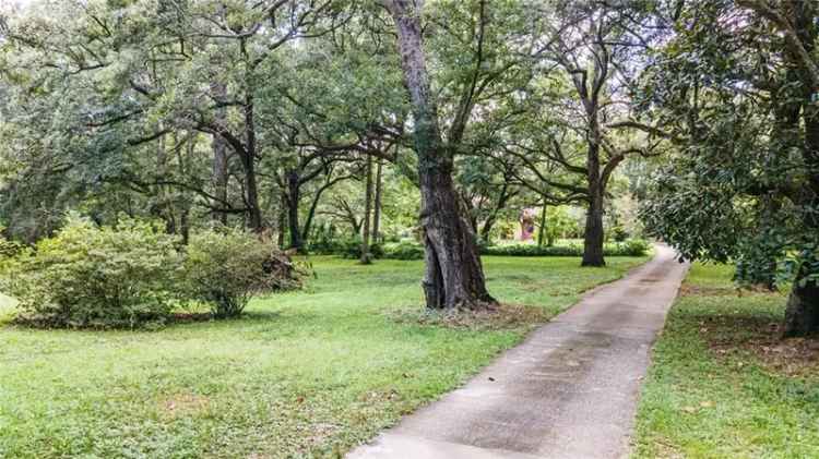 Spanish style home for sale in Grand Bay with lush acreage and unique features